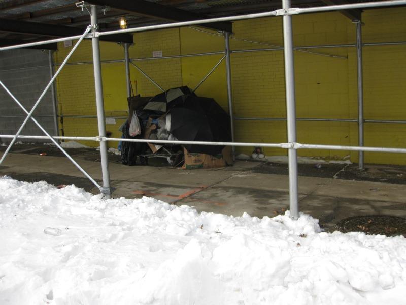 A homeless woman in Prospect Heights, Brooklyn builds a makeshift shelter from the snow.